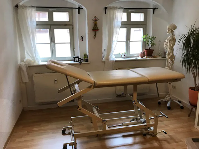 Behandlungsraum mit Liege für Patienten und anatomischen Skelettmodell